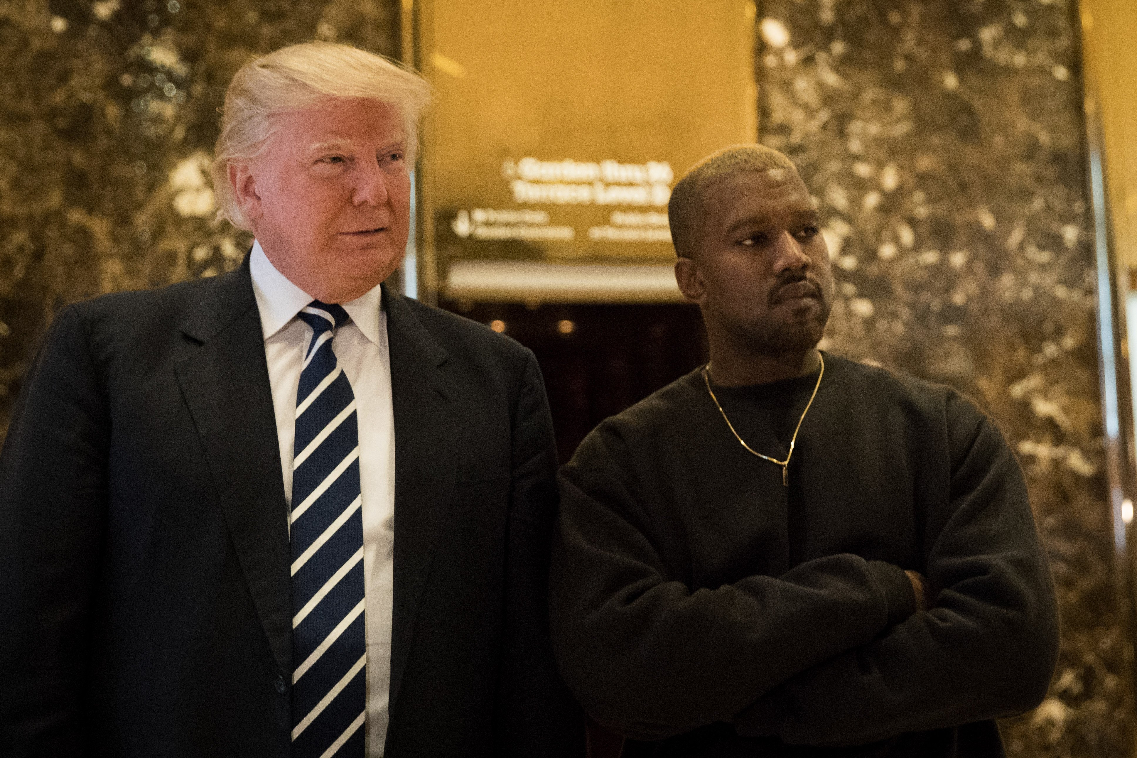 President-elect Donald Trump and Kanye West stand together in the lobby at Trump Tower, December 13, 2016 in New York City.