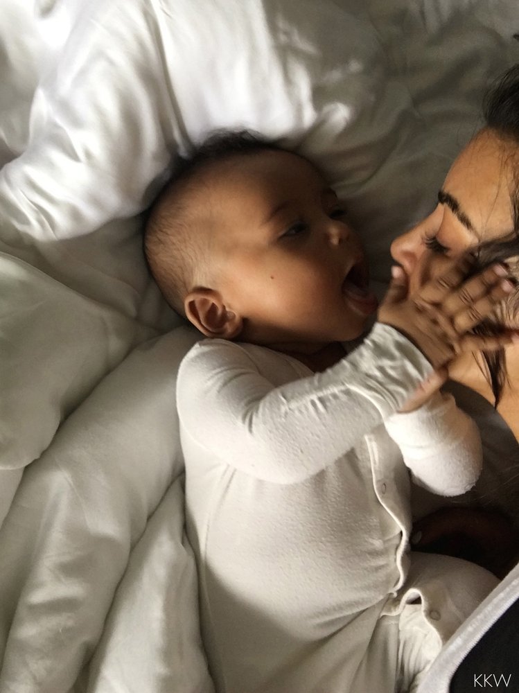 Saint West cuddles with mom Kim Kardashian in a photo posted to her official website on Dec. 5, 2016