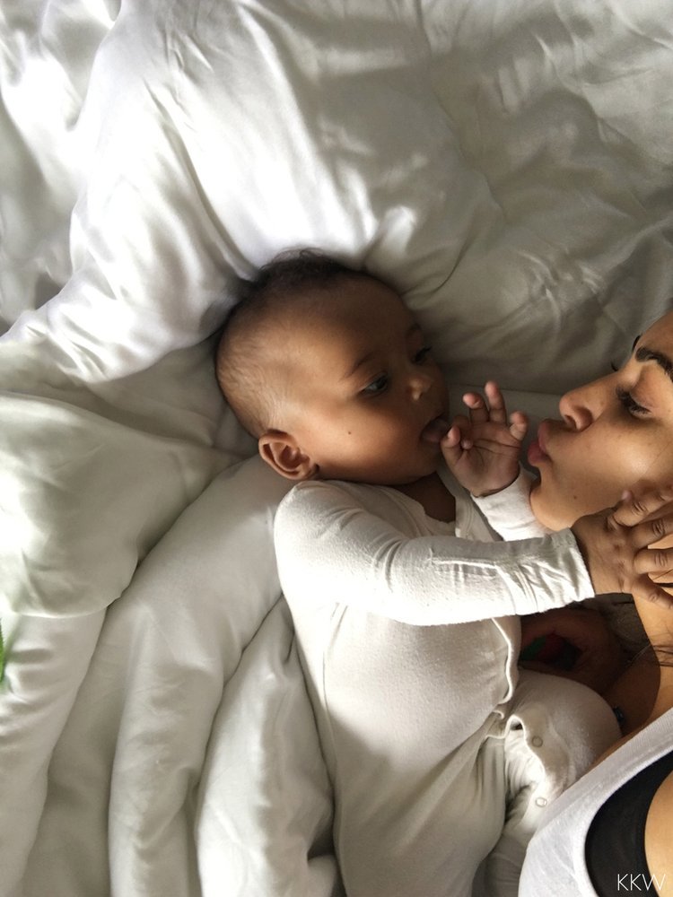 Saint West cuddles with mom Kim Kardashian in a photo posted to her official website on Dec. 5, 2016