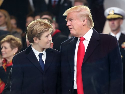 Donald Trump stands with his son Barron Trump inside of the inaugural parade reviewing stand in front of the White House on January 20, 2017 in Washington, DC.