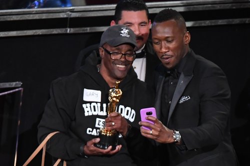 A tourist brought into the Oscars as a surprise meets with Best Supporting Actor winner Mahershala Ali at the 89th Oscars on February 26, 2017 in Hollywood