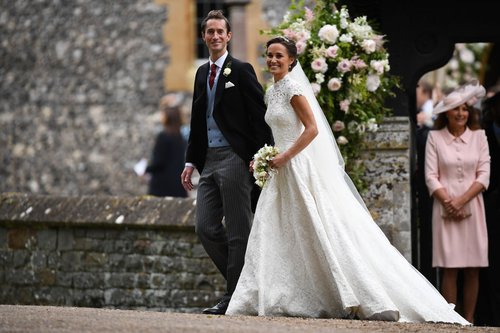 Pippa Middleton and her new husband James Matthews leave church following their wedding ceremony at St Mark's Church as the bridesmaids and pageboys walk ahead on May 20, 2017 in Englefield Green, England