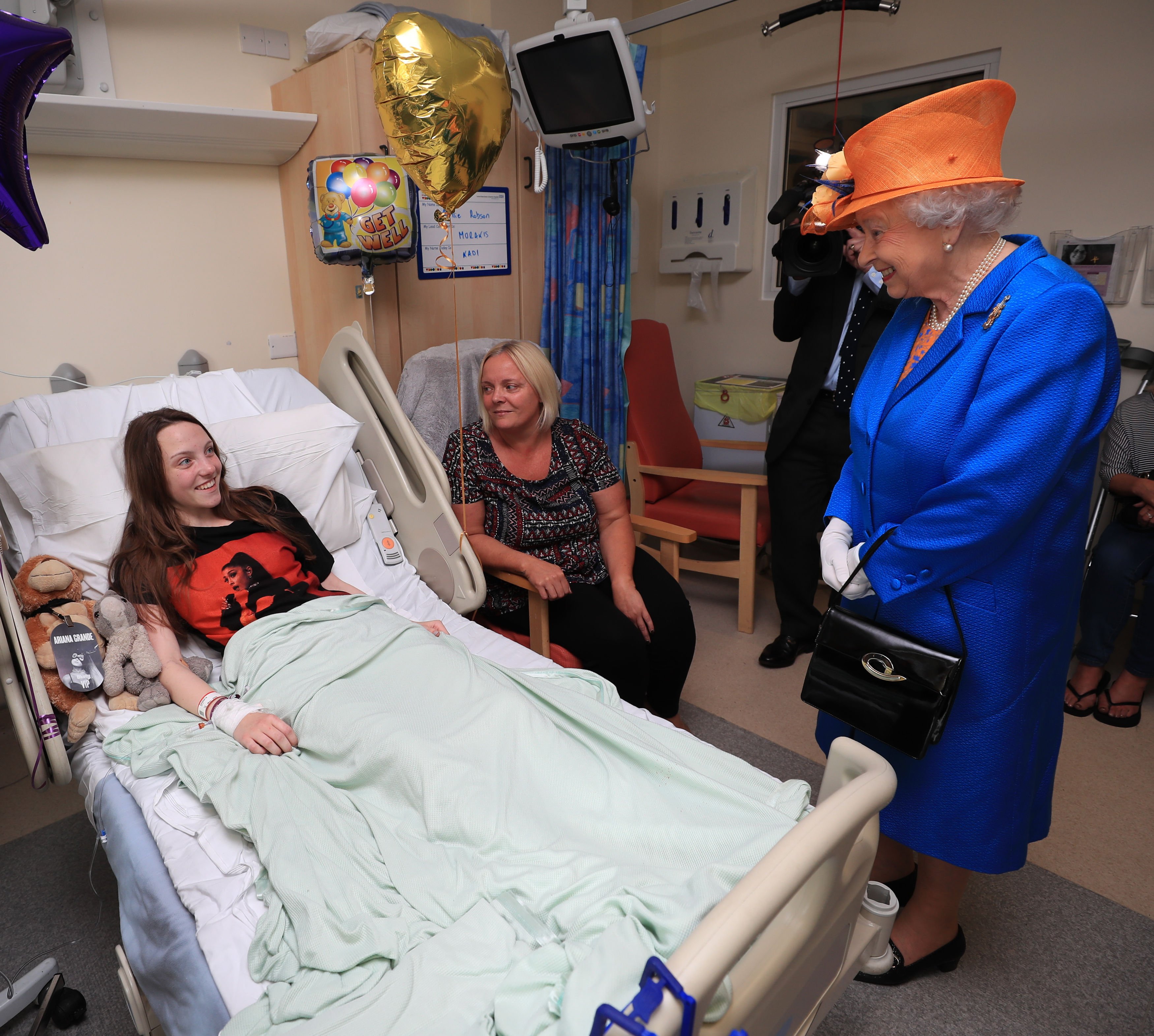 Queen Elizabeth II speaks to Millie Robson, 15, from Co Durham, and her mother, Marie, during a visit to the Royal Manchester Children's Hospital to meet victims of the terror attack on May 25, 2017