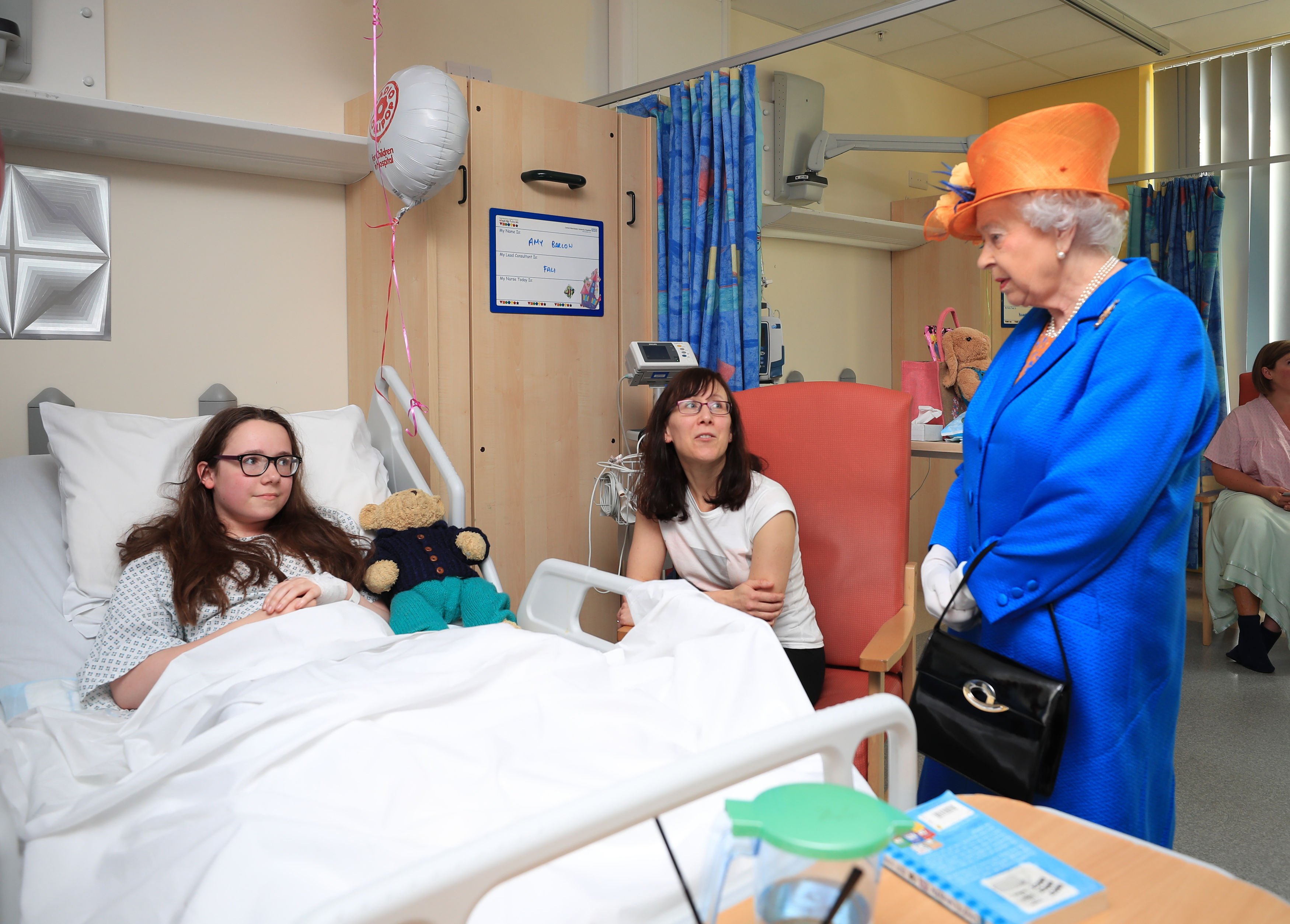 Queen Elizabeth II speaks to Amy Barlow, 12, from Rawtenstall, Lancashire, and her mother, Kathy during a visit to the Royal Manchester Children's Hospital to meet victims of the terror attack on May 25, 2017