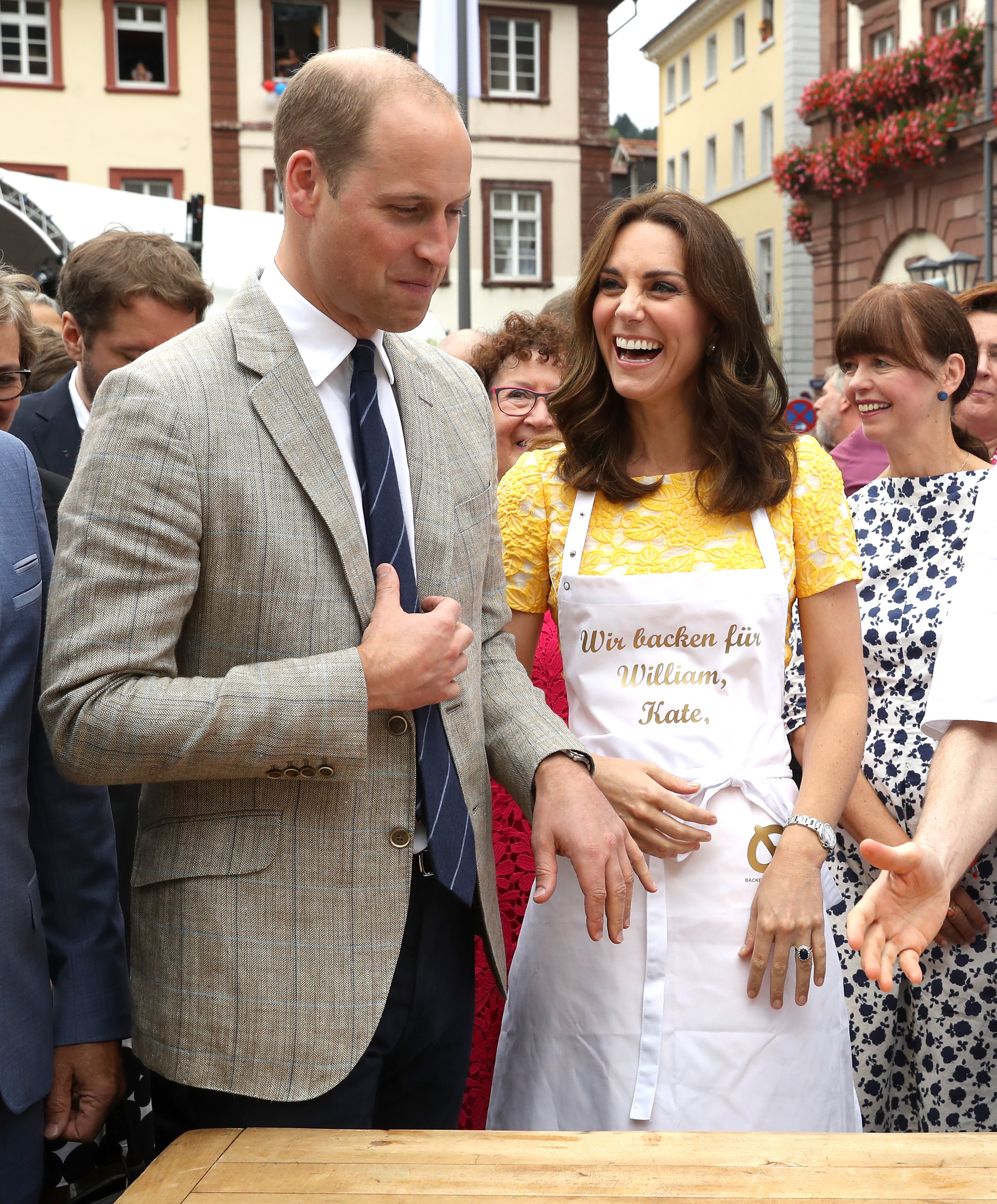 Prince William, Duke of Cambridge and Catherine, Duchess of Cambridge attempt to make pretzels during a tour of a traditional German market in the Central Square on day 2 of their official visit to Germany on July 20, 2017 in Heidelberg, Germany
