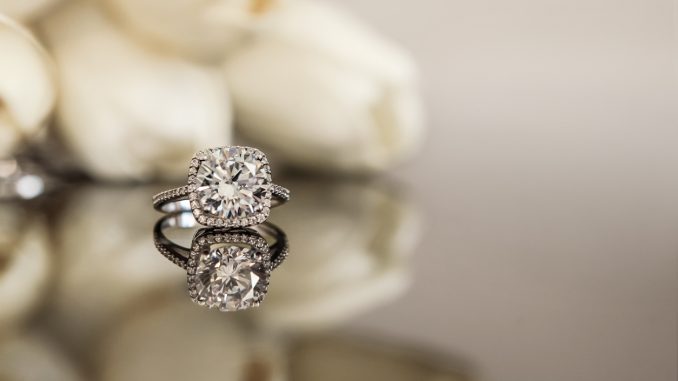 engagement ring on table with white flowers in background